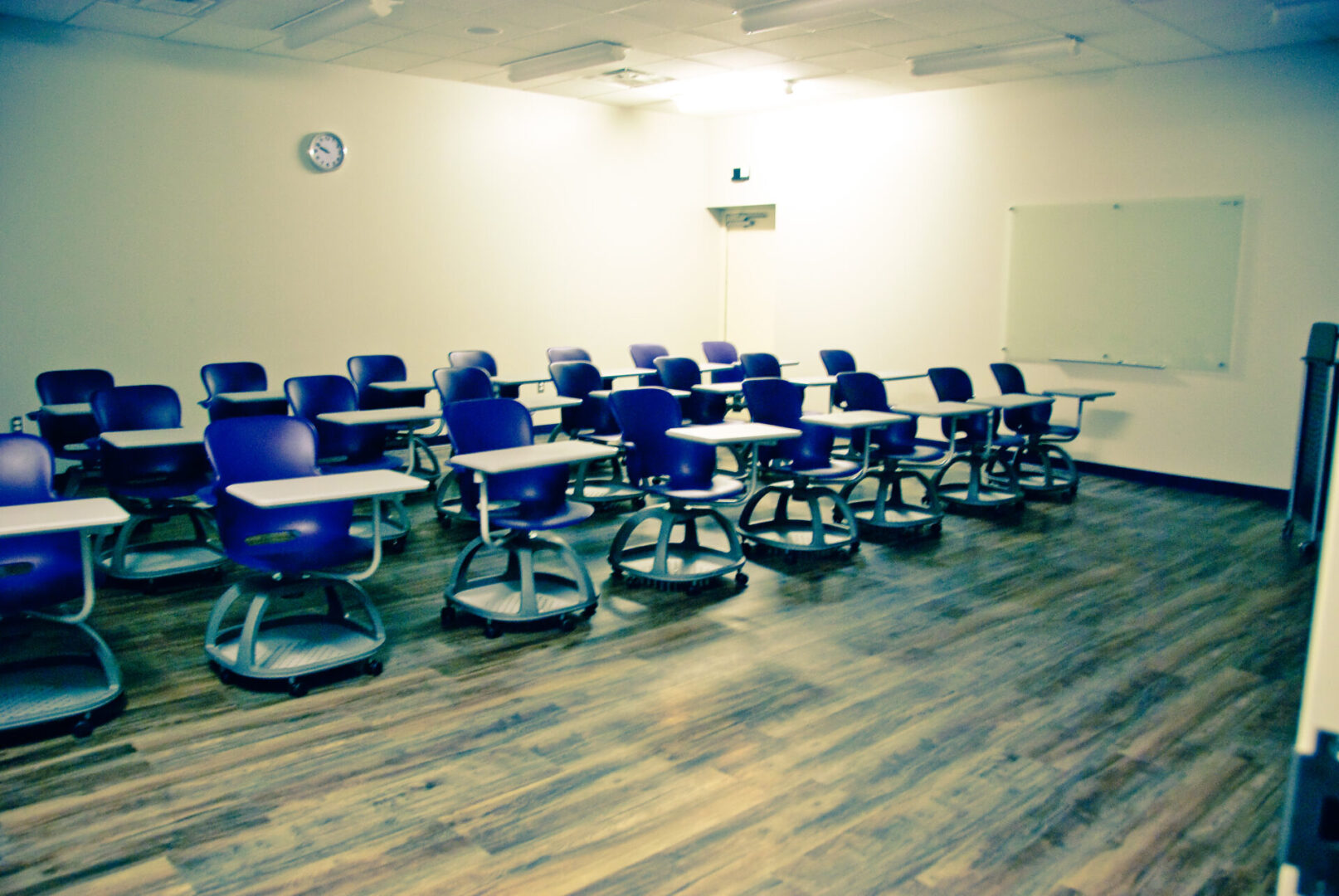 A classroom with many blue chairs and tables