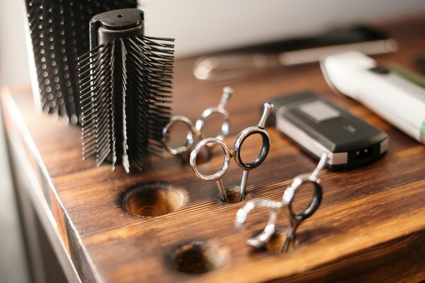 A wooden table with some scissors and combs on it