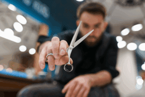 Close-up of barber’s hands expertly wielding scissors.