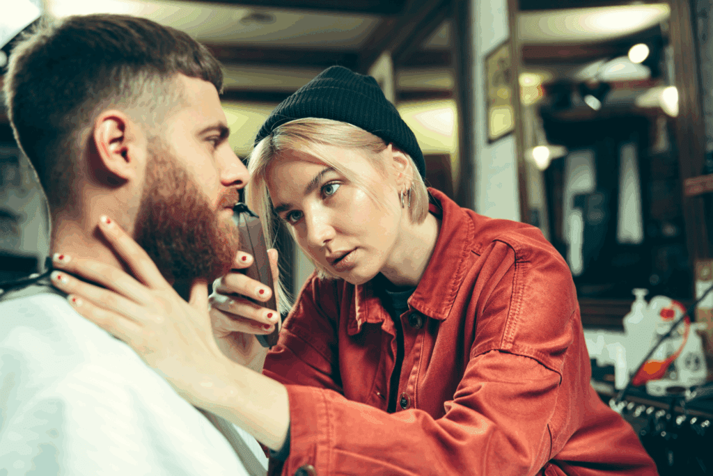 Barber student trims client’s beard.