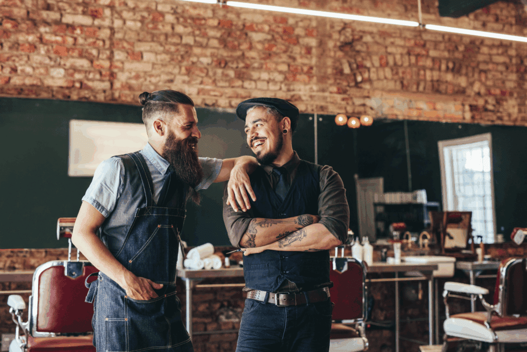 Two smiling male barbers.